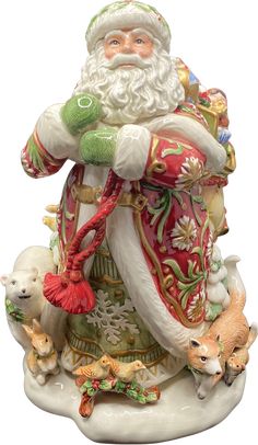 a santa clause figurine sitting on top of a white base with animals around it