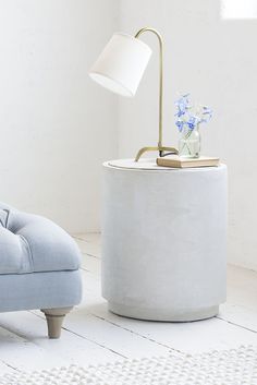 a living room with a blue chair and a white lamp on the end table in front of it