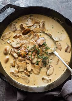 a skillet filled with mushroom soup on top of a table