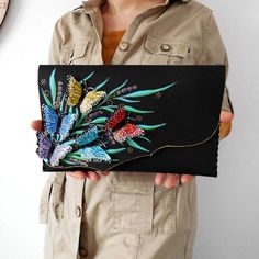 "\"Rainbow Butterflies\" is a unique cut black clutch with lots of colorful Morpho Butterflies and painted flowers  for people who love unusual purses/colorful bags and can be a quirky and awesome anniversary/gift for her.w  You can also find more butterflies if you follow this link : https://www.etsy.com/shop/spiculdegrau?ref=hdr_shop_menu&section_id=21096579 Made of leather and 3D hand cut leather pieces Hand painted and using collage technique. With magnetic clasp closure. The interior is ful Red Evening Bag, Unique Leather Bag, Painted Leather Bag, Butterfly Bag, Bohemian Purse, Artist Bag, Rainbow Butterflies, Painted Butterfly, Bridesmaid Clutches