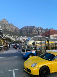 a yellow sports car parked in front of a bus on the side of the road