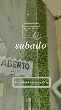 a glass door with the words sabado in spanish and an image of grass growing on it