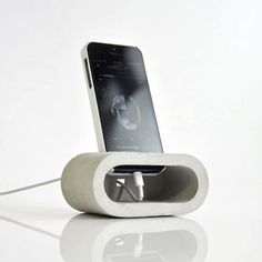 an electronic device is plugged in to a charging station on a white table top