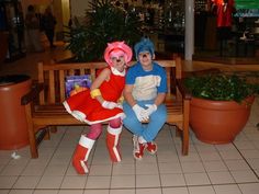 two people in costumes sitting on a bench