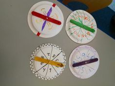 four paper plates with different designs and numbers on them, each painted to look like a clock