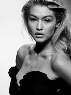 a black and white photo of a woman with long hair wearing a strapless dress