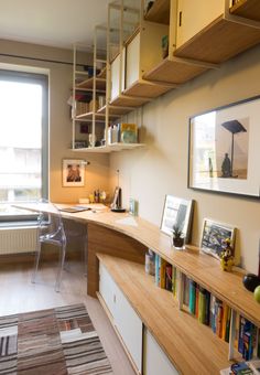 a room with a desk, bookshelf and pictures on the wall next to it