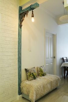 a room with a white brick wall and green trim on the door way to another room