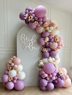 the balloon arch is decorated with flowers and balloons