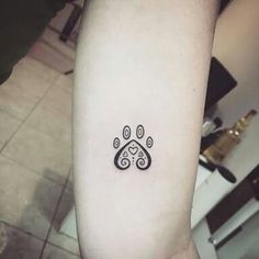 a dog paw tattoo on the left inner arm