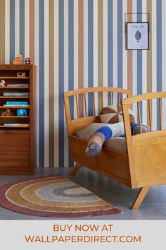 a child's bedroom with striped wallpaper and wooden furniture