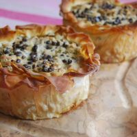 two quiches sitting on top of a piece of parchment paper next to each other