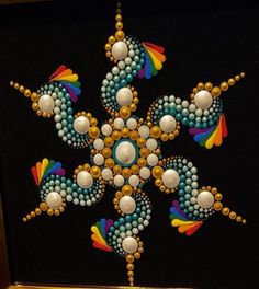 the beaded snowflake is on display in front of a black background with gold trim