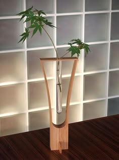 a vase with a plant in it sitting on a table next to a tile wall