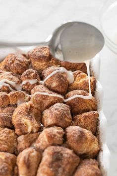 cinnamon rolls are being drizzled with icing