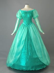 a woman's green gown on display in a museum case, with the dress worn by princess aurora