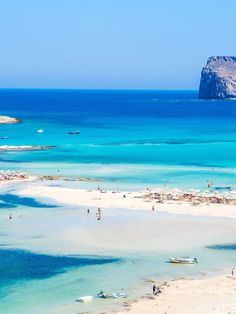 the beach is crowded with people and boats