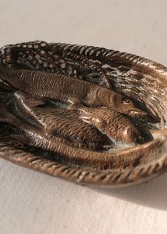 a metal bowl with an animal design on the bottom and sides, sitting on a white surface