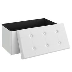 a white and black box with buttons on the lid is sitting in front of a white background