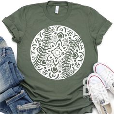 a t - shirt with an image of a flower on the front and bottom, next to some shoes