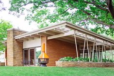 a modern house with an outdoor fireplace in the front yard