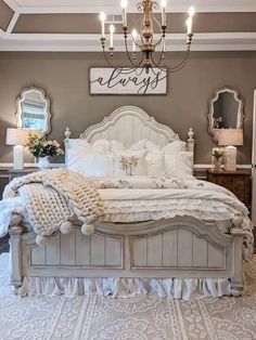 a white bed sitting under a chandelier in a bedroom