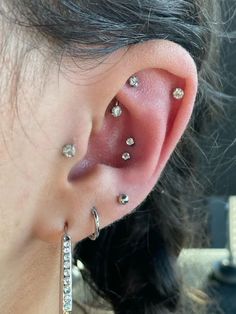 a close up of a person's ear with multiple piercings on the side