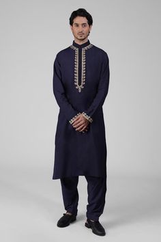 Navy blue kurta featuring intricate tilla embroidery and delicate gold silk thread work on the front placket, sleeves, and neckline. Paired with a pathani salwar.
Components: 2
Pattern: Embroidered
Type Of Work: Tilla
Neckline: Band collar
Sleeve Type: Long
Fabric: Silk
Color: Blue
Other Details: 
Attached lining
Length:
Kurta: 47 inches
Sleeve: 27 inches
Placket: 15.5 inches
Salwar: 42 inches
Occasion: Mehendi and Puja - Aza Fashions Pathani Salwar, Tilla Embroidery, Pathani Kurta, Blue Kurta, Kurta Men, Straight Kurta, Gold Silk, Bandana Print, Band Collar