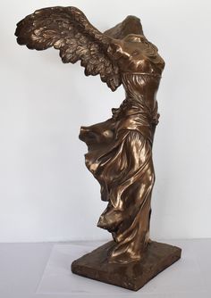 a bronze statue of an angel with wings on it's back and arms outstretched