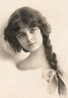 an old black and white photo of a woman with a big bow on her head