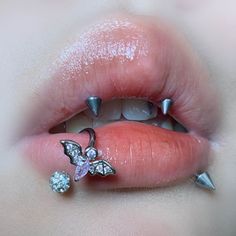 a woman's lips with some piercings on them