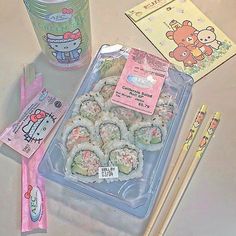 there are sushi and chopsticks on the table with hello kitty stickers