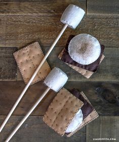 two marshmallows are sitting on top of some brown and white crackers