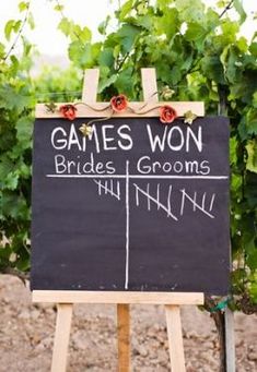 a sign that says games won brides and grooms written on it in front of some vines