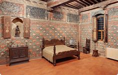 an old fashioned bedroom is decorated with wallpaper and wood furniture, including a bed