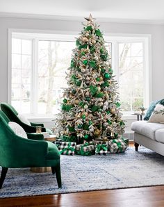 a living room with a christmas tree decorated in green and gold ribbons, plaid pillows, and two chairs