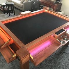 a coffee table with an illuminated drawer underneath it in the middle of a living room