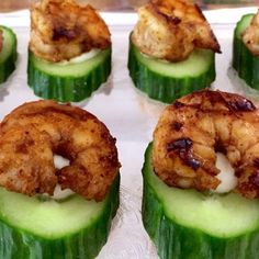 cucumbers with shrimp on them sitting in a tray