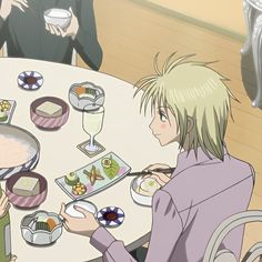 two people sitting at a table eating food