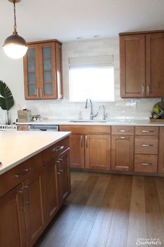 a kitchen with wooden cabinets and white counter tops