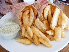 french fries and dip on a plate at a restaurant