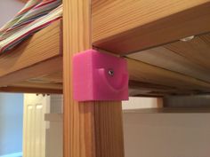 a pink object on the bottom of a wooden bunk bed