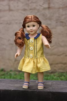 a doll with red hair wearing a yellow dress