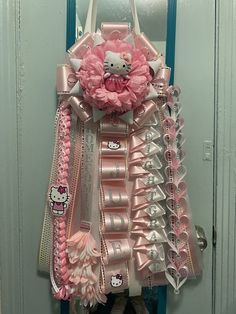 a hello kitty themed door hanger with pink and silver decorations on it's side