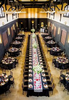 a long table with flowers on it is set up in the middle of a hall