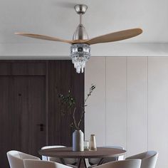 a dining room table with four chairs and a ceiling fan in the middle of it