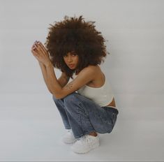 a woman with an afro sitting on the ground