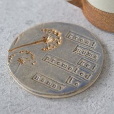 a close up of a medal on the ground with a cup in the back ground