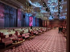 an empty banquet hall with chandeliers hanging from the ceiling and chairs lined up in rows