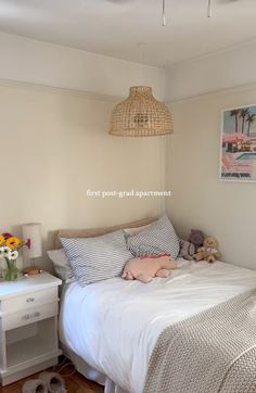 a bedroom with a bed, nightstand and pictures on the wall